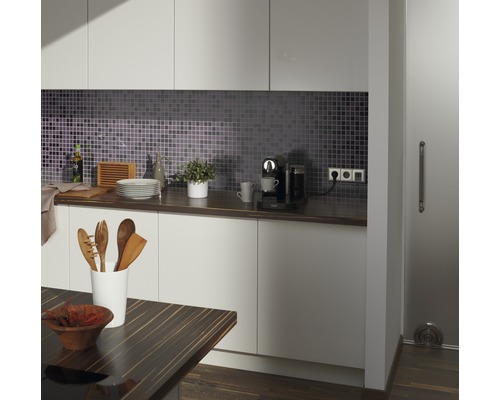 Bucătărie modernă cu gresie mozaic, blat, ustensile de bucătărie și aparat de cafea.