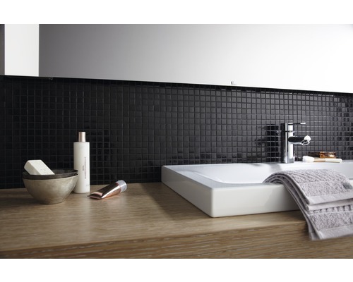 Baie modernă cu lavoar, robinet, prosop și plăci de mozaic