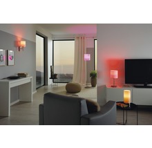Cameră de zi cu lămpi iluminate, fotoliu și mobilier de living