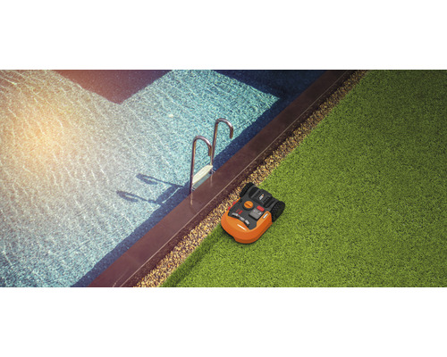 Robot de tuns iarba lângă piscină pe gazon