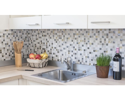 Chiuvetă de bucătărie cu robinet, plăci de mozaic și ustensile de bucătărie pe blat