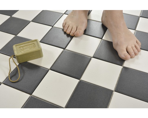 Plăci pătrate în model de tablă de șah cu o bucată de săpun și picioare