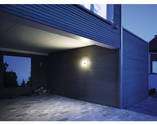 Exteriorul unei case cu design modern, cu iluminat exterior și alee pavată