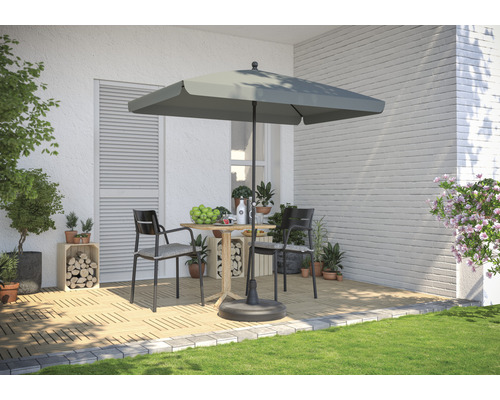 Scenă cu umbrelă de soare pătrată, masă și două scaune pe o terasă