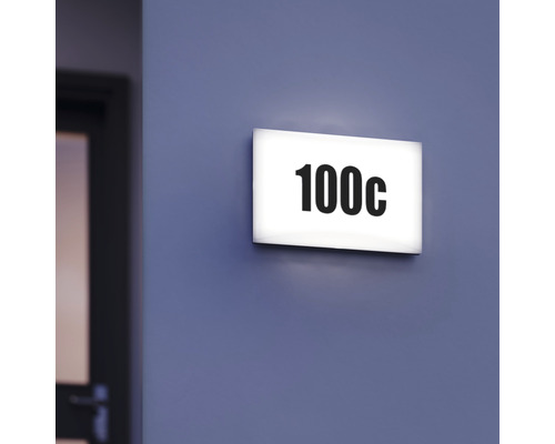 Placă de ușă iluminată cu numărul 100c pe un perete