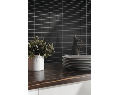 Scenă de bucătărie cu faianță neagră, blat de lemn, veselă și decorațiuni