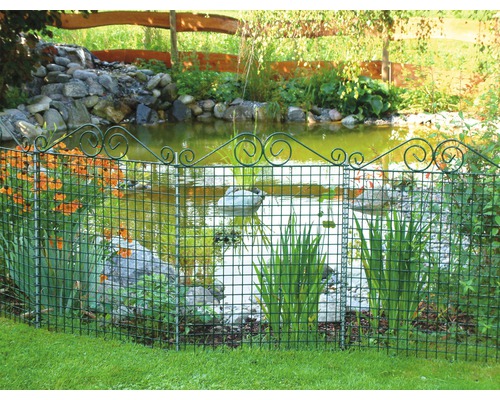 Iaz de grădină înconjurat de un gard metalic decorativ verde