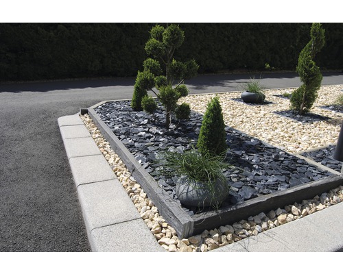 Grădină amenajată cu plante, pietre și borduri de gazon