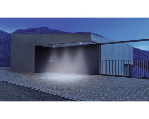 Alee iluminată cu arhitectură modernă și peisaj montan în fundal