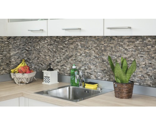 Scenă de bucătărie cu chiuvetă, robinet, plăci de mozaic și decorațiuni pe un blat de lucru