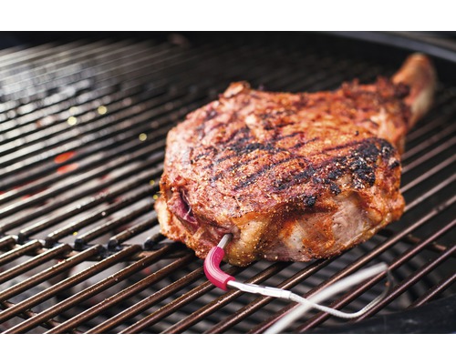Bucată de carne Tomahawk pe grătar cu termometru pentru carne