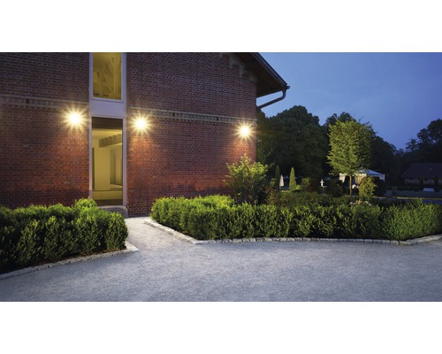 Fotografie exterioară a unei case cu zidărie și iluminat de grădină