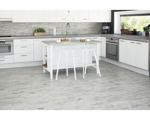 Bucătărie luminoasă cu insulă de bucătărie, scaune de bar, dulapuri și aparate electrice.