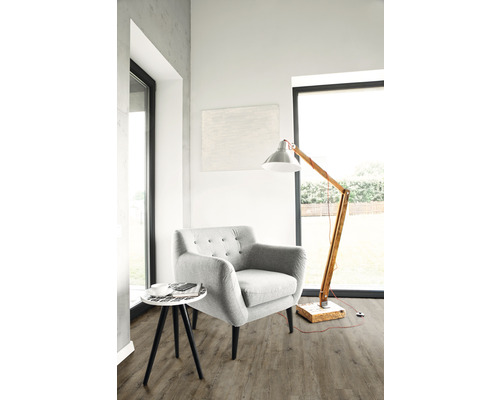 Cameră de zi luminoasă cu fotoliu, lampadar și măsuță laterală pe podea