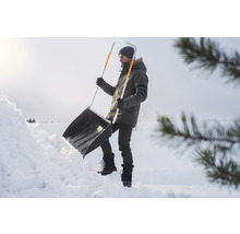 Bărbat care curăță zăpada cu o lopată de zăpadă