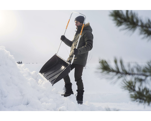 Bărbat care curăță zăpada cu o lopată de zăpadă