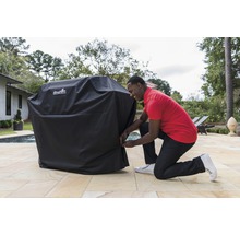 Husă neagră pentru grătar care protejează un grătar de exterior.