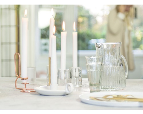 Masa decorativă cu lumânări, sfeșnice, pahare și un ulcior