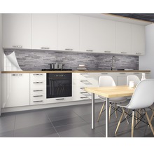 Bucătărie modernă cu dulapuri albe, blat de lucru din lemn și perete din piatră gri