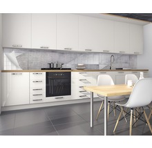 Bucătărie modernă cu dulapuri albe, blat de lucru din lemn și placă de protecție în aspect de beton