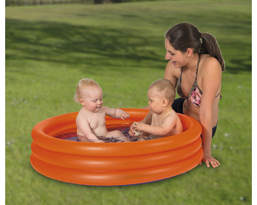 Bazin gonflabil pentru copii cu doi copii și o femeie în grădină.