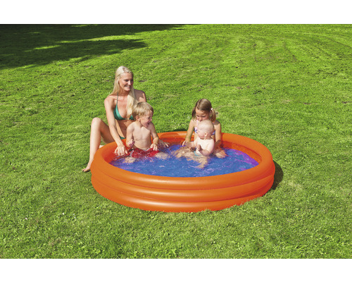 Piscină gonflabilă pentru copii cu copii jucându-se și o femeie în grădină.