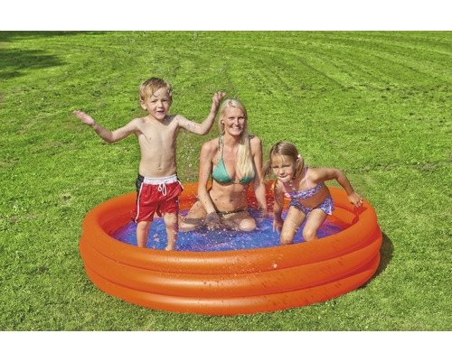 Familie cu copil într-o piscină gonflabilă în grădină