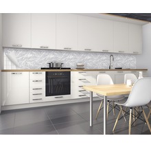 Bucătărie modernă cu corpuri de bucătărie albe, masă și panouri de perete cu model de frunze