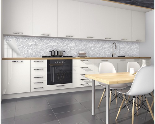 Bucătărie modernă cu corpuri de bucătărie albe, masă și panouri de perete cu model de frunze