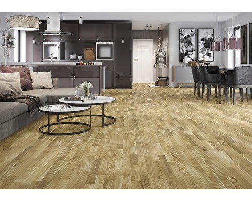 Podea deschisă la culoare, din lemn, într-un spațiu de locuit modern, cu bucătărie și zonă de luat masa.