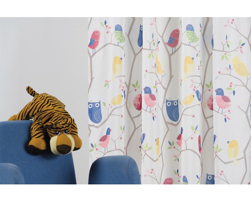 Material decorativ cu motive de păsări și un animal de pluș pe un fotoliu