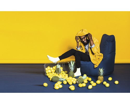 Bărbat stând într-un fotoliu cu lămâie și ananas