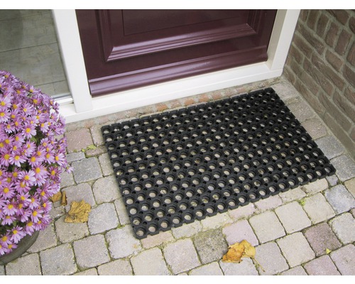 Covoraș de cauciuc negru în fața unei uși de intrare