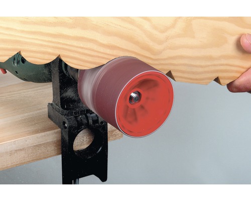 O mașină de șlefuit cu fus șlefuiește o piesă de prelucrat din lemn.