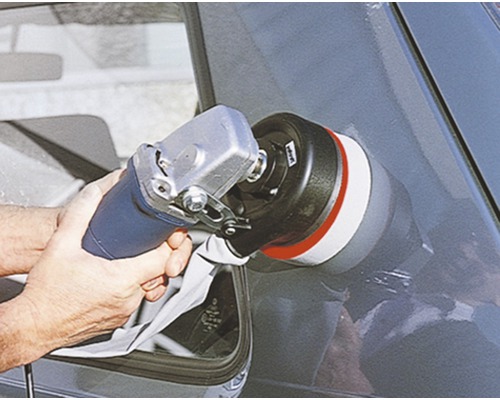 O persoană lustruiește o mașină cu o mașină de lustruit.