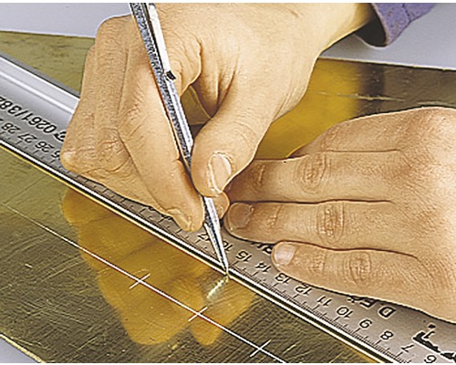 O persoană marchează o foaie de metal cu un pix și o riglă.