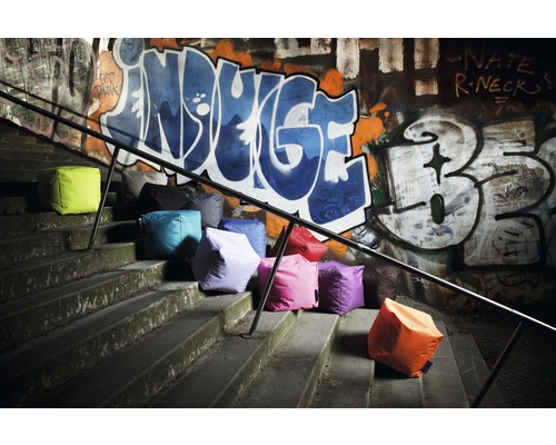 Mai multe cuburi de șezut pe scări în fața unui perete cu graffiti