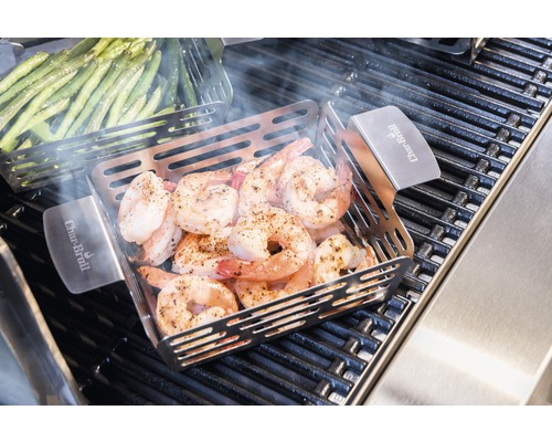 Creveți la grătar într-o tigaie pentru grătar cu frigărui de legume pe un grătar.