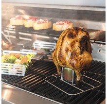 Pui la grătar pe un suport de băuturi cu legume și felii de pâine în fundal.