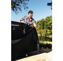 Bărbat așază o husă de protecție peste un grătar în aer liber cu logo-ul Char-Broil