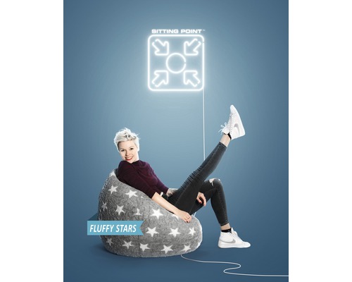 Femeie șezând într-un sac de fasole gri cu model cu stele sub un logo ''Sitting Point''