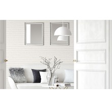 Cameră de zi luminoasă cu canapea, perne, masă, decorațiuni, lămpi, oglinzi și ușă deschisă.