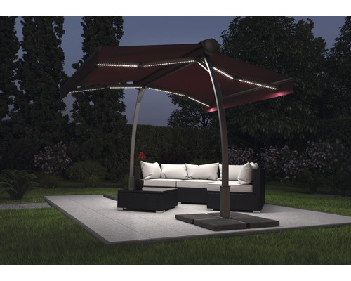 Scenă de grădină cu o umbrelă suspendată cu iluminare LED deasupra unui set de lounge