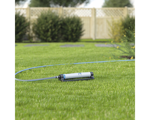 Aspersor de grădină cu furtun pe gazon