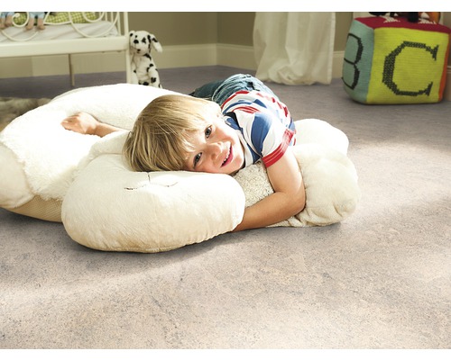 Cameră de copii cu podea de plută și copil pe o pernă