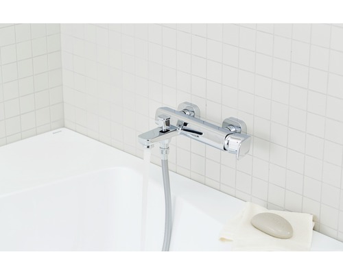 Imagine cu o baterie de cadă cromată cu apă curgătoare într-o baie luminoasă