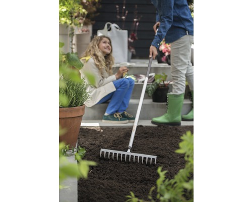 Scenă de grădinărit cu greblă și două persoane