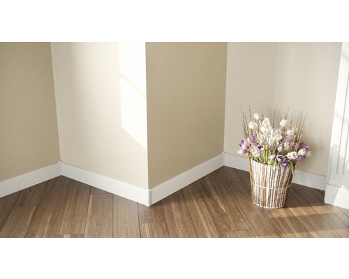 Colț de cameră cu plinte albe, podea din lemn și un buchet de flori într-un vas decorativ.