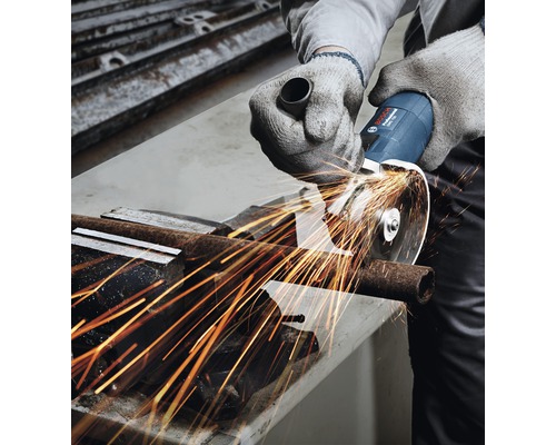 O persoană taie o țeavă metalică cu un polizor unghiular, cu scântei zburând.