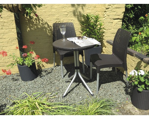 Scenă de grădină cu masă de bistro și două scaune din ratan afară.